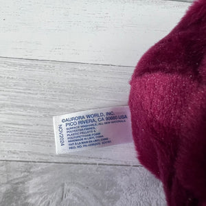 Close-up of a label on a plush toy with a blurred red fabric background