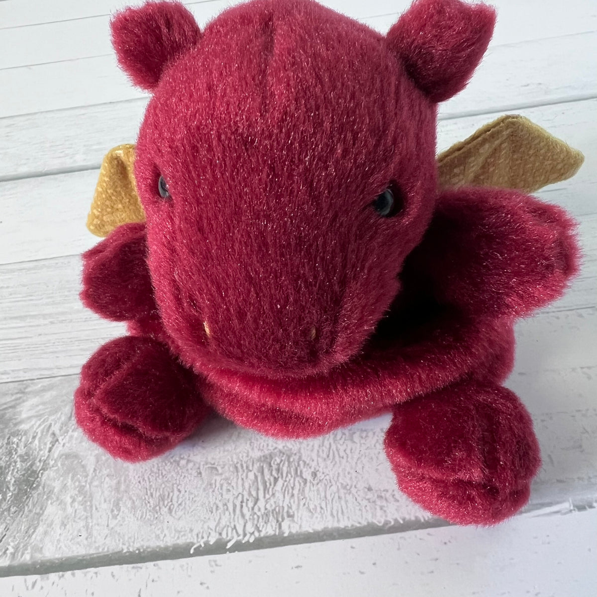 Plush dragon toy on a wooden surface