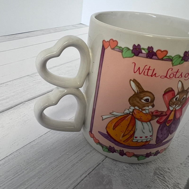 Mug with rabbit illustration and heart-shaped handle on a wooden surface