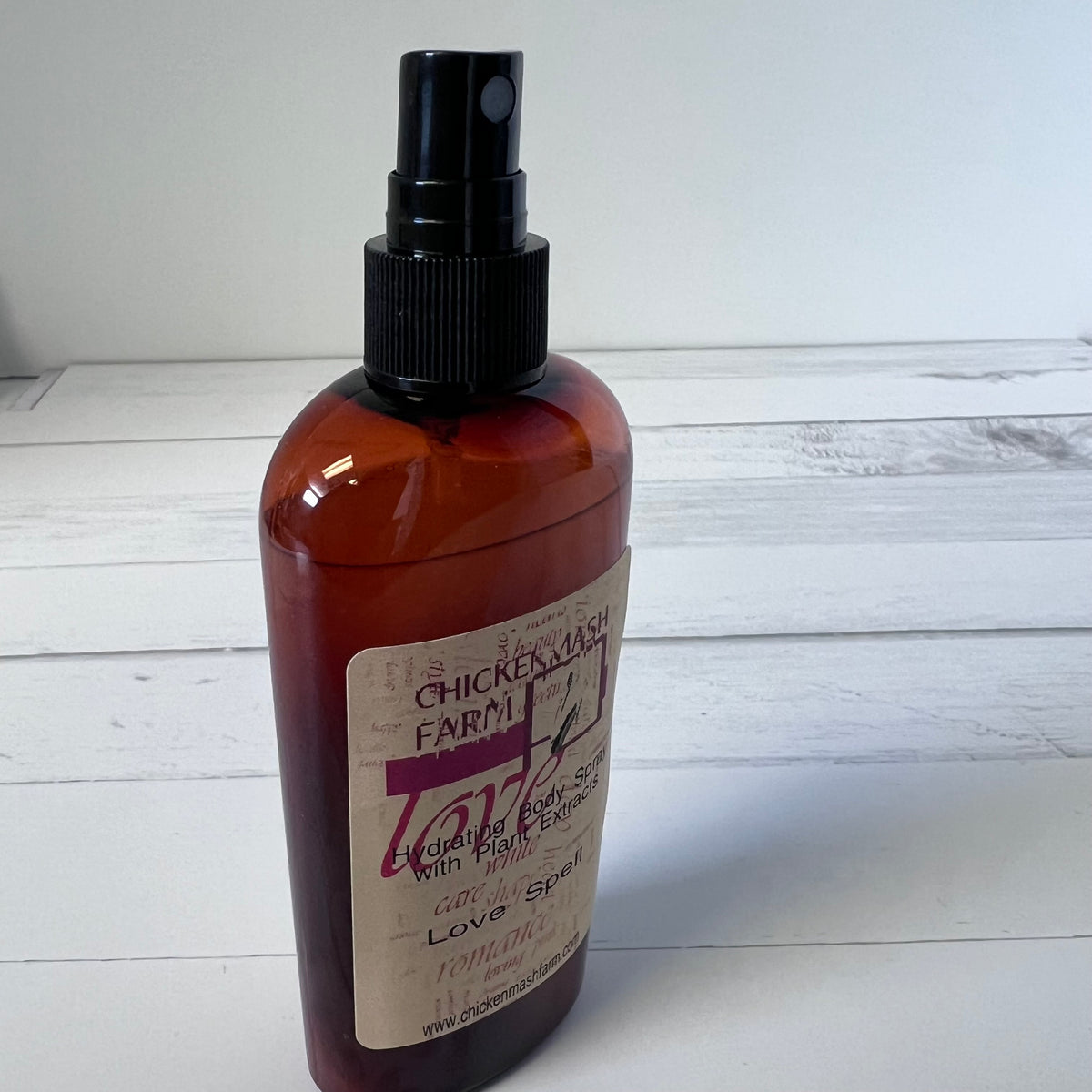 Brown spray bottle with a label on a white wooden surface