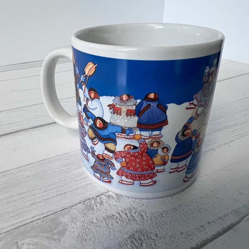 Mug with a colorful design of people in winter clothing on a white wooden surface.