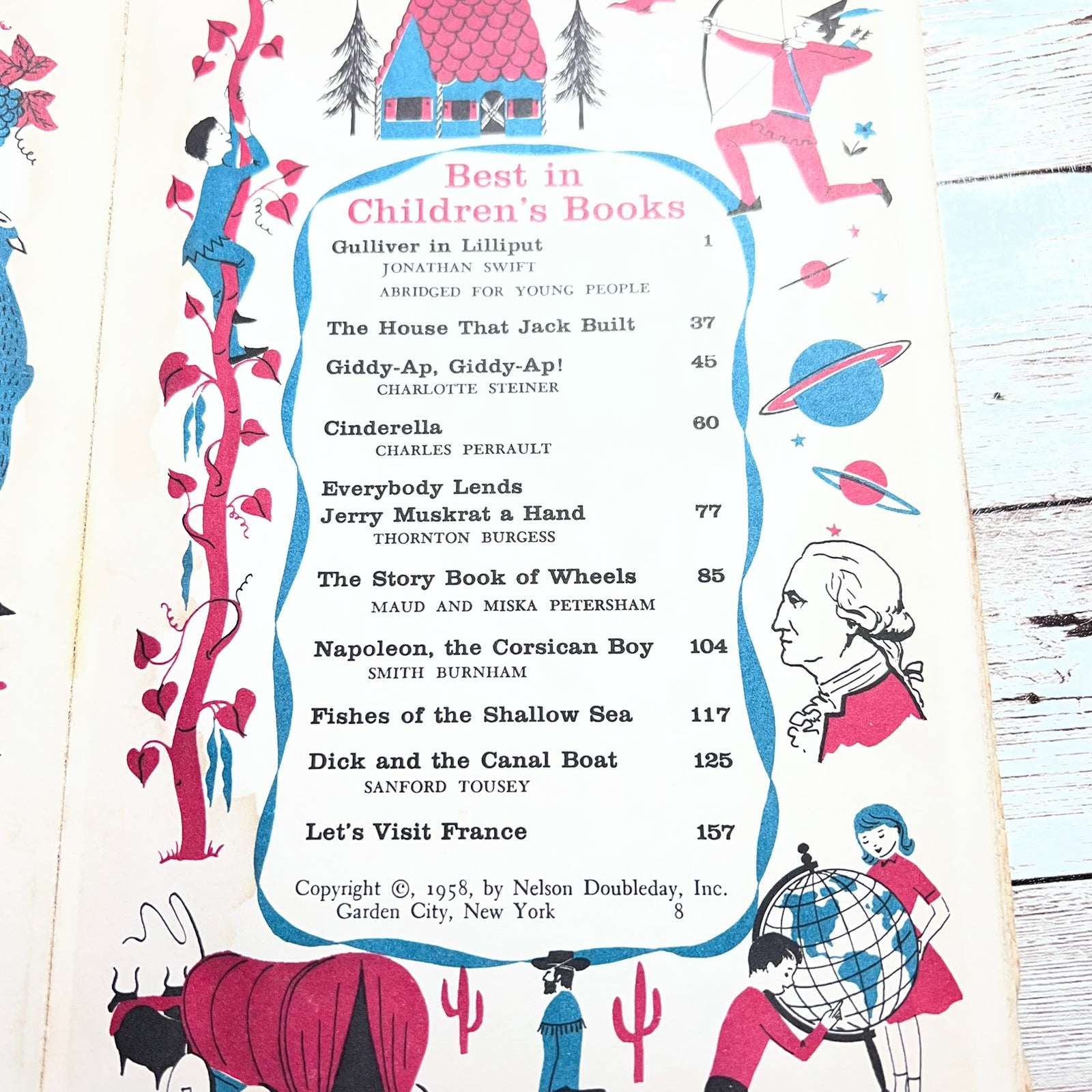 A vintage illustrated book or booklet page titled "Best in Children's Books" with a list of books and small colorful drawings around the border, photographed on a light wood surface.
