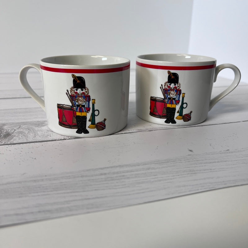 Two mugs with decorative designs on a white surface