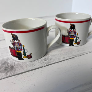 Two mugs with nutcracker design on a white surface