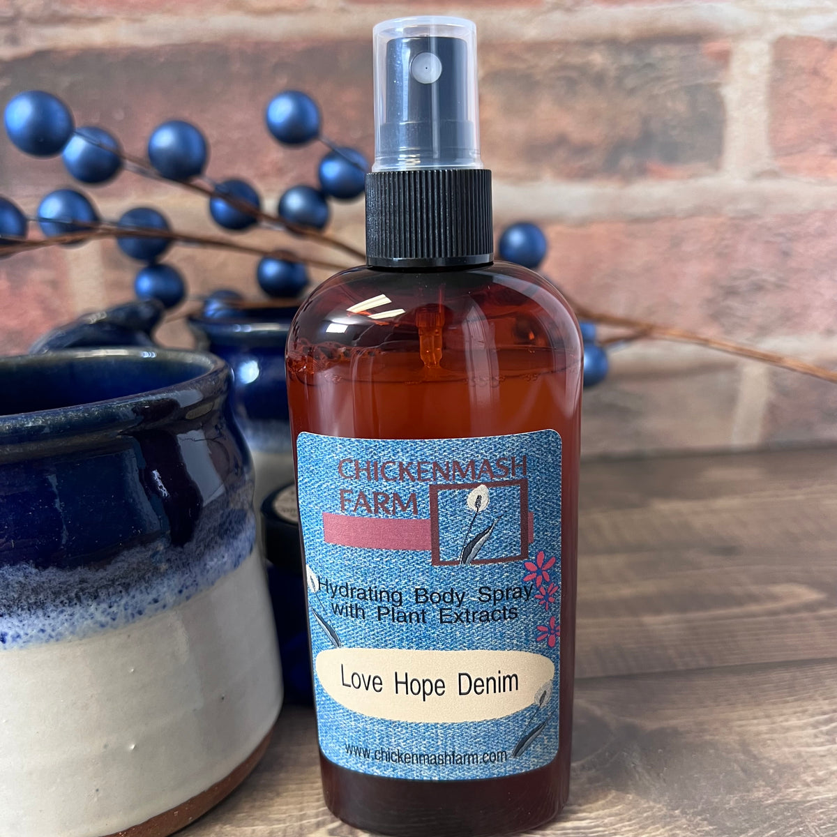 Bottle of Chickenmash Farm body spray with a label on a wooden surface.