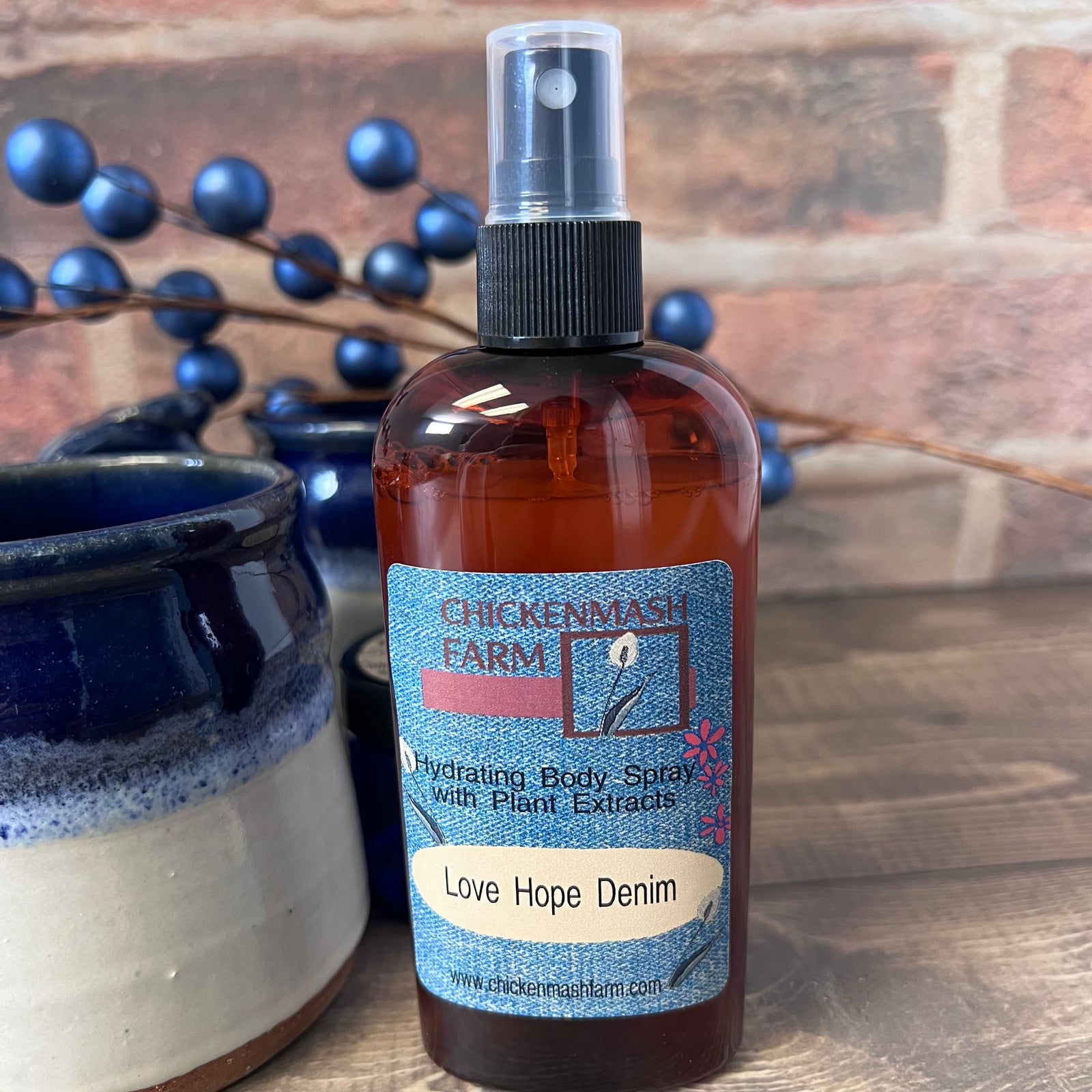 Bottle of Chickenmash Farm body spray with a label on a wooden surface.
