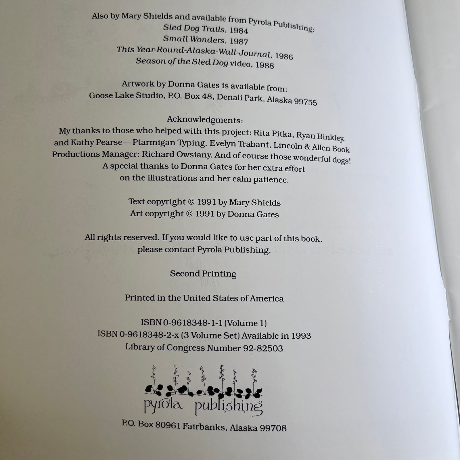 A photographed book cover or printed publication page with text about sled dog trails and acknowledgments, plus the Pyrola Publishing name and logo at the bottom. The page is mostly white with black text and a small black-and-white logo.