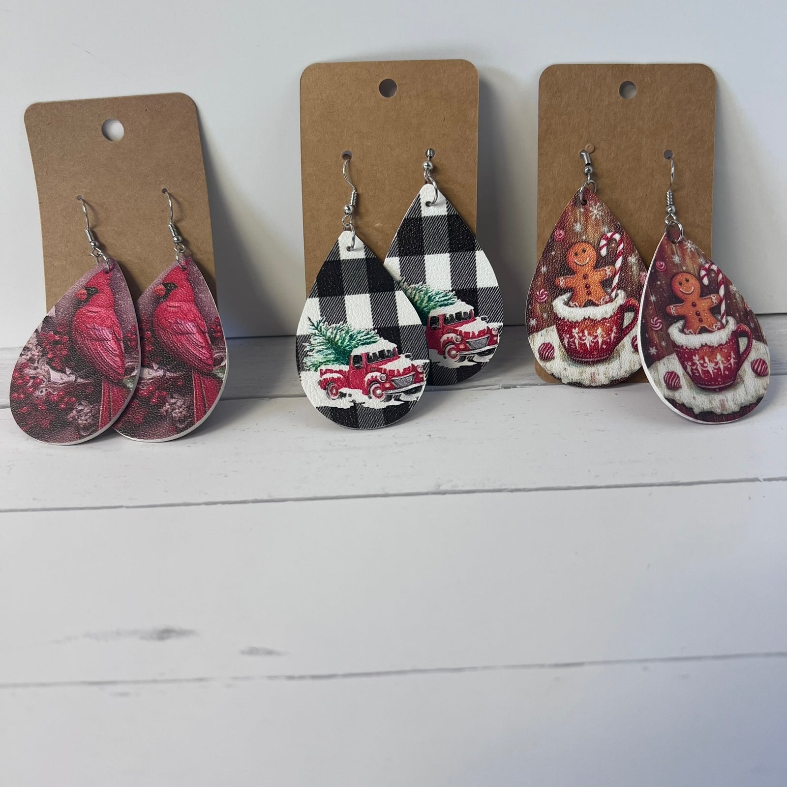 Set of Christmas-themed teardrop earrings on brown card backing.