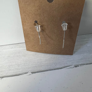Pair of earrings on a cardboard backing with a plain background