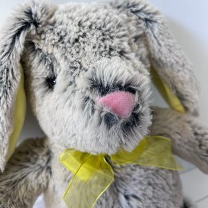 Plush bunny toy with a yellow bow on a white background