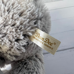 Close-up of a plush toy with a 'Dan Dee' tag on a light wooden background