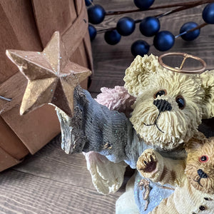 Decorative arrangement with a star, small animal figurines, and blue berries on a wooden surface.
