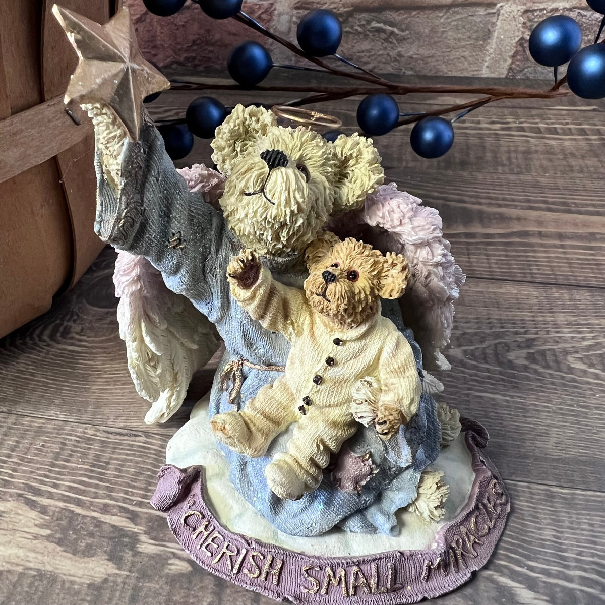 Decorative figurine with two teddy bears and a star on a wooden surface.