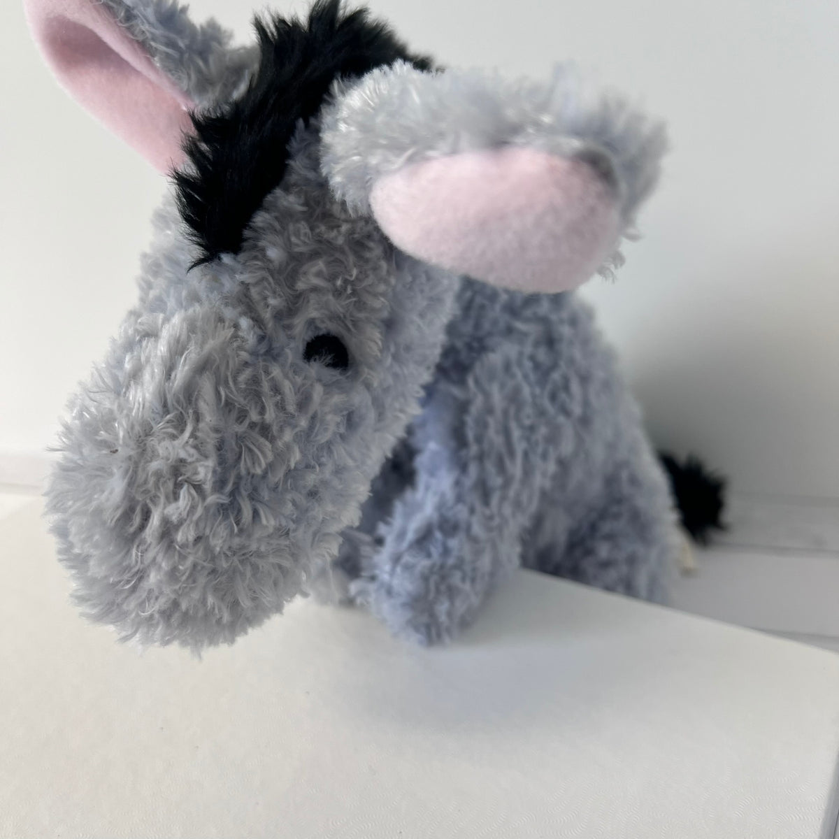 Plush donkey toy on a white surface with a neutral background