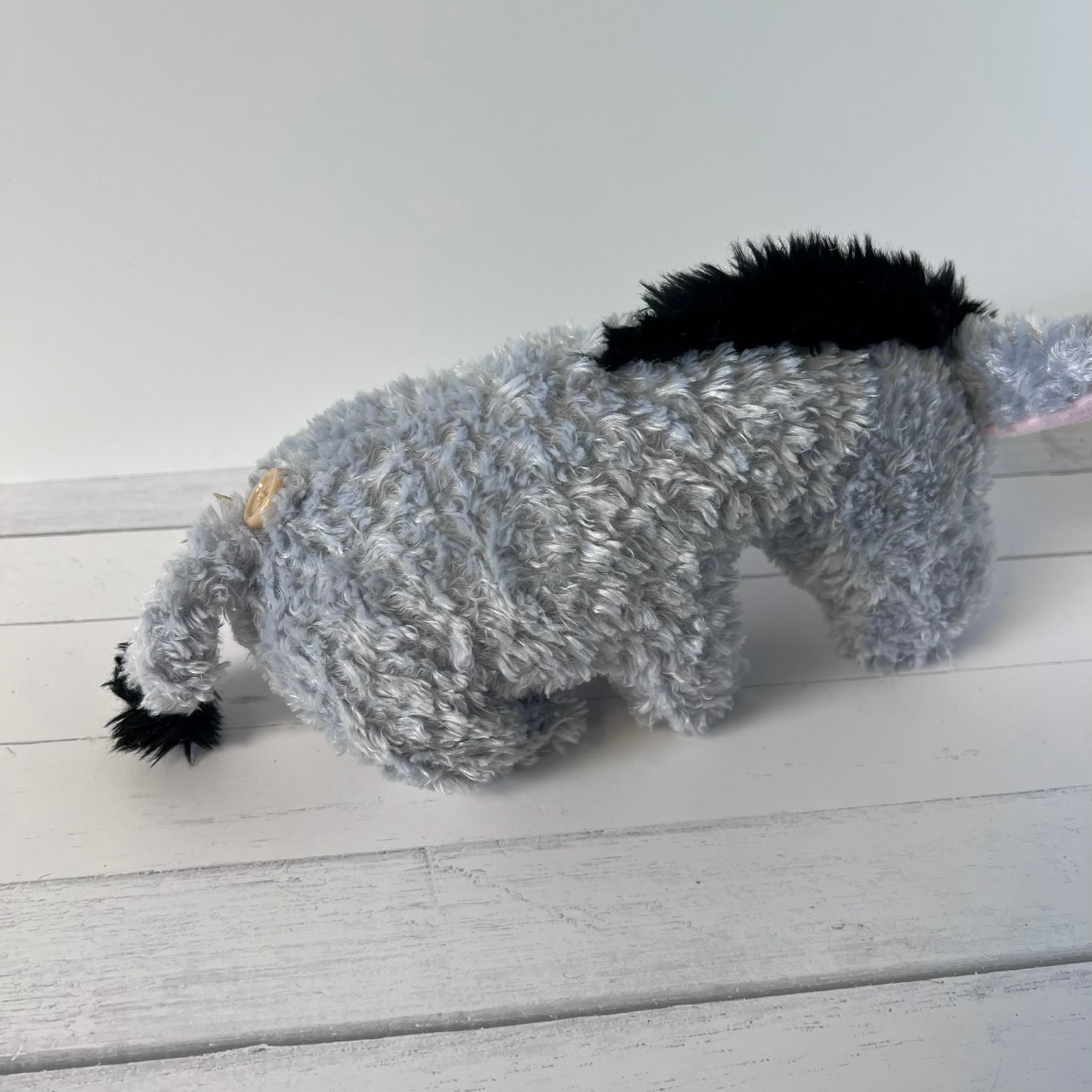 Plush toy resembling a donkey on a white wooden surface