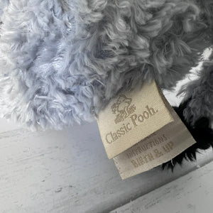 Close-up of a fluffy gray toy with a 'Classic Pooh' label on a light gray background