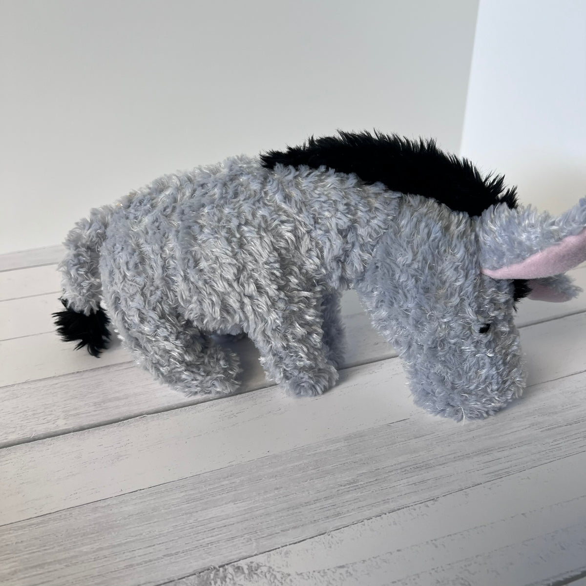 Plush toy resembling a donkey on a wooden floor