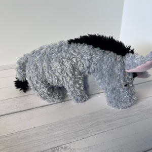 Plush toy resembling a donkey on a wooden floor