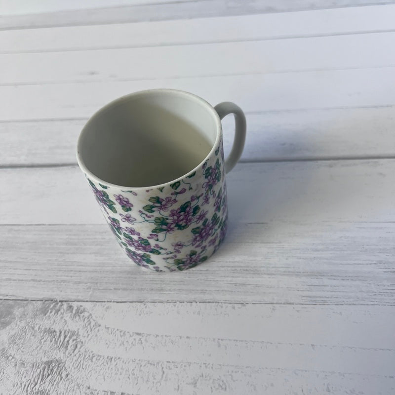 Floral-patterned mug on a white wooden surface