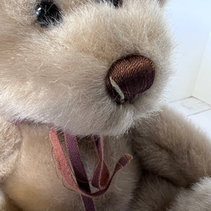 Close-up of a plush toy resembling a white mouse with a brown nose.