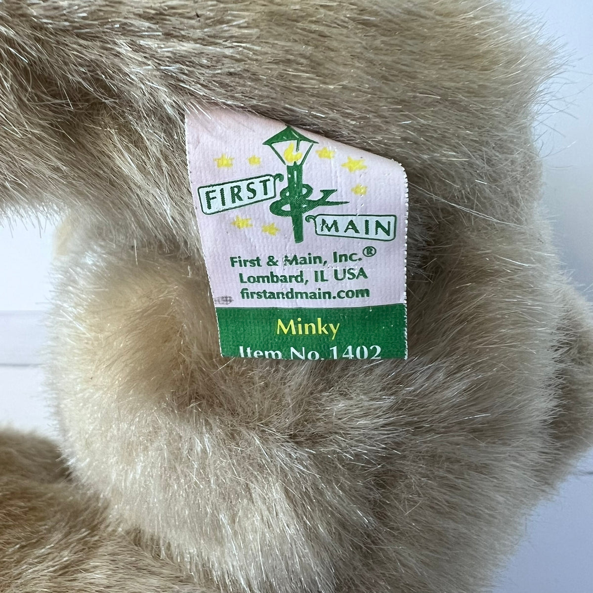 Close-up of a minky fabric with a 'First & Main' label on a white background
