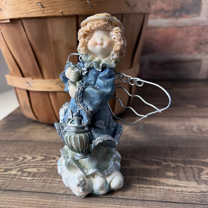 Decorative figurine of a angel with a lantern on a wooden surface
