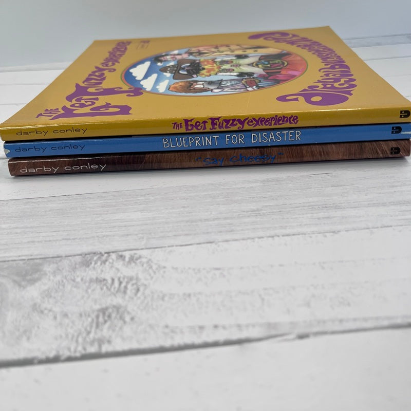 Three books by Darby Conley stacked on a light wooden surface