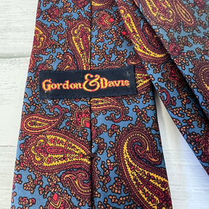 Paisley patterned tie with 'Gordon & Davis' label on a white background