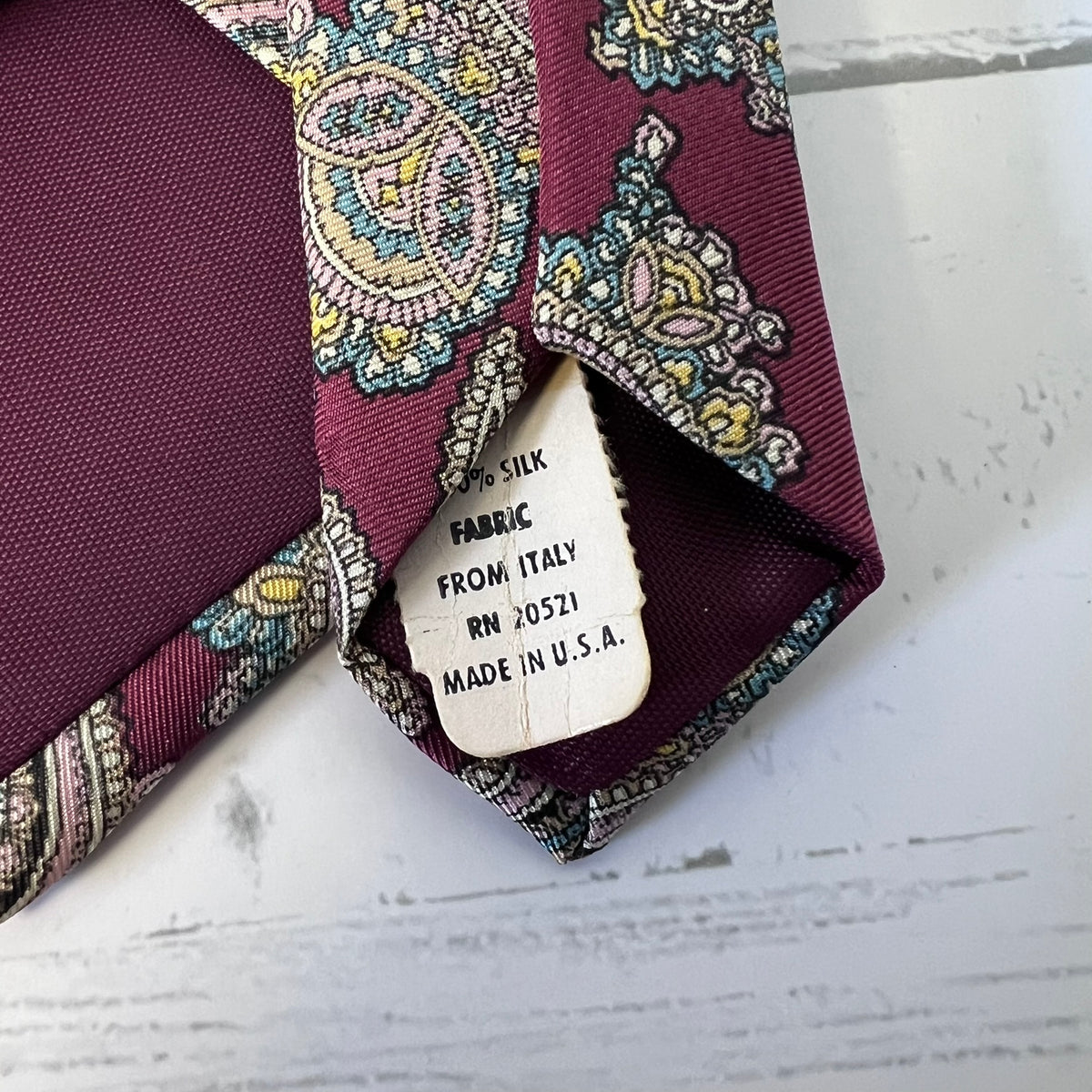 Patterned tie with a label on a white surface
