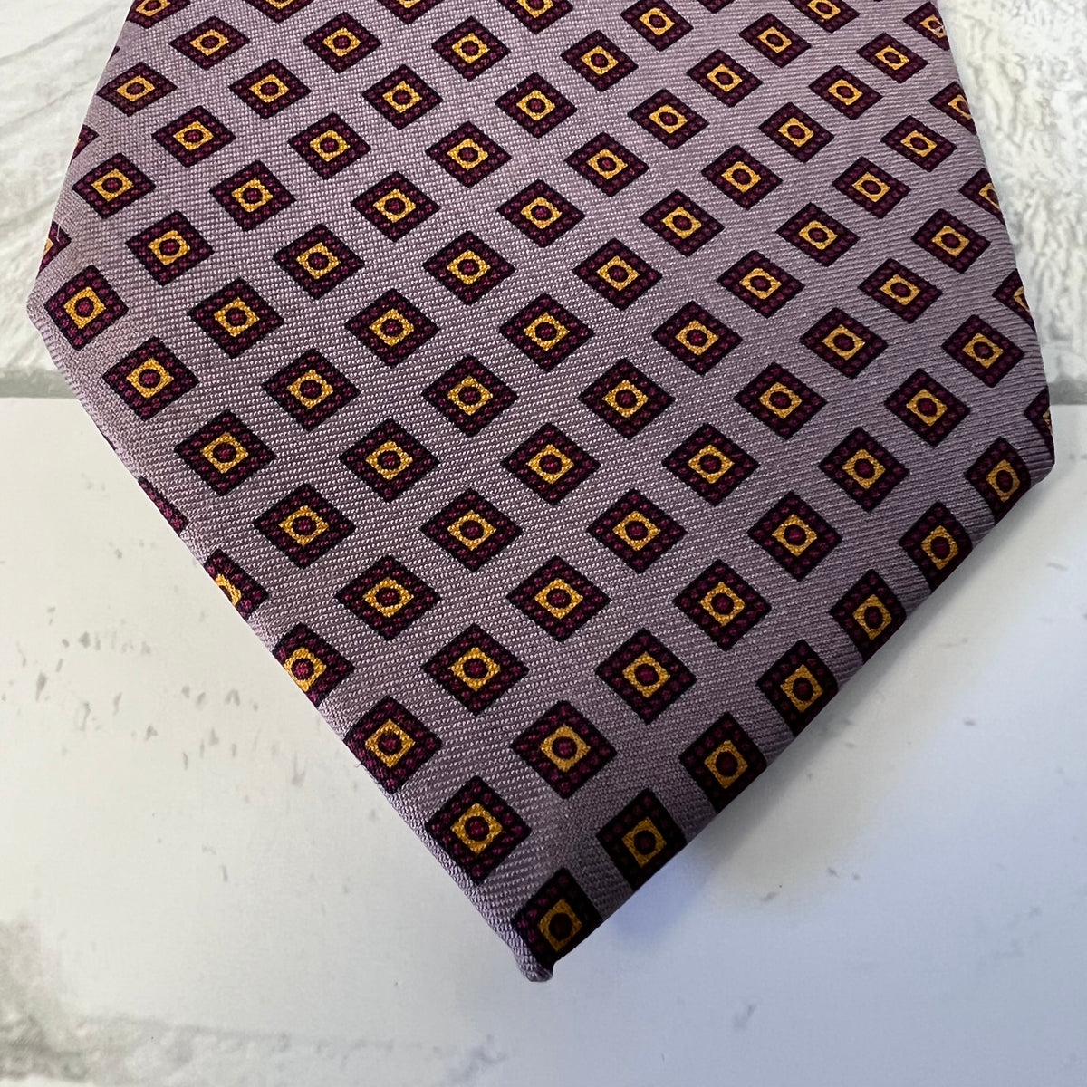 Patterned tie on a textured white surface