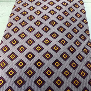 Navy and yellow patterned tie on a gray background