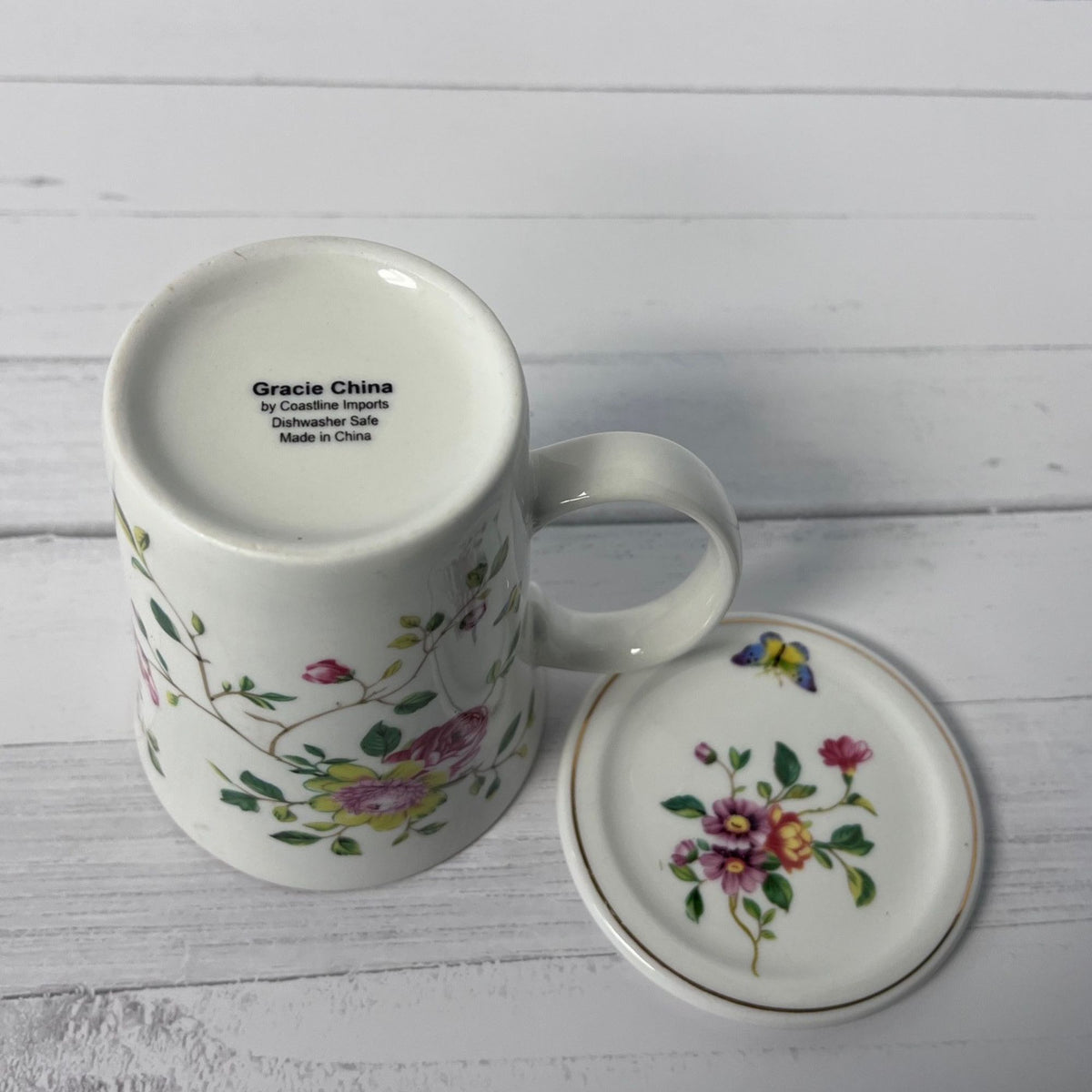 White mug with floral design on a white wooden surface