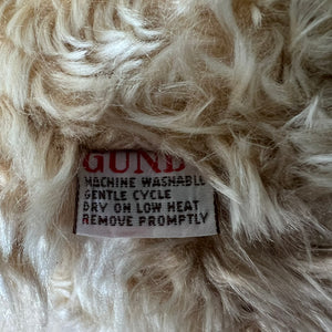 Close-up of a label on fluffy white fabric with text.