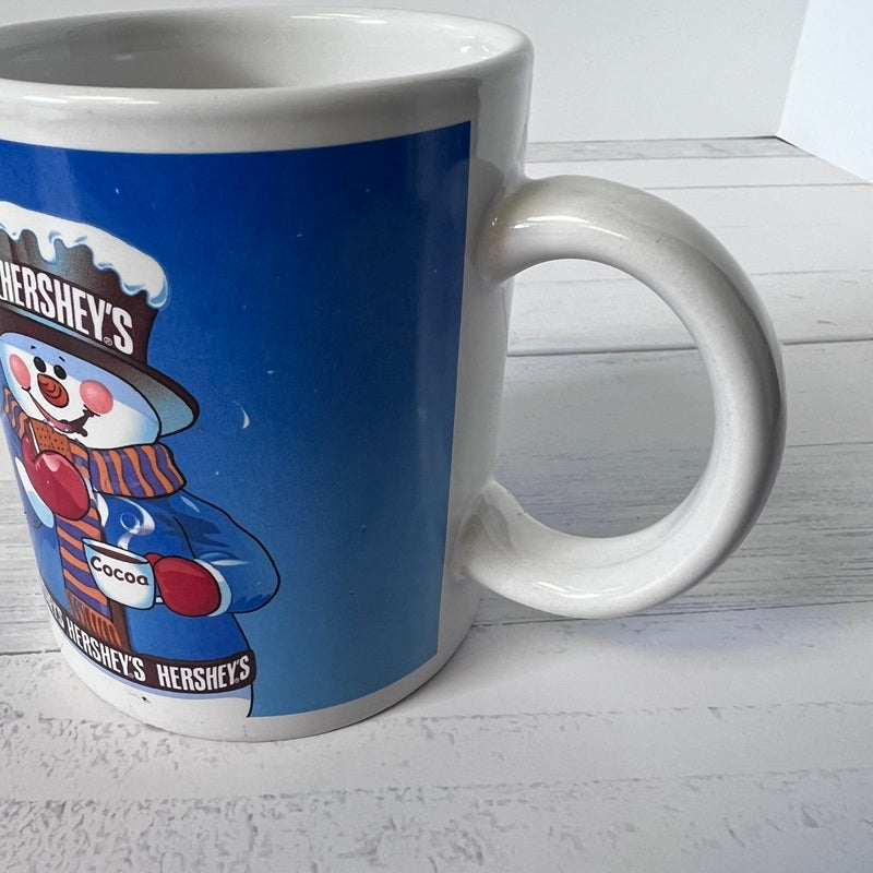 White mug with Hershey's chocolate-themed design on a white wooden surface