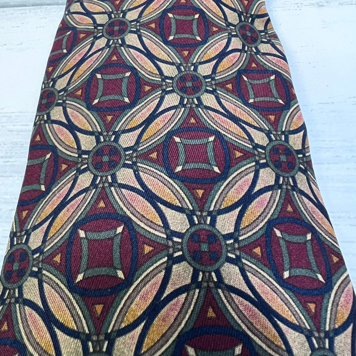 Patterned tie with geometric design on a light blue background