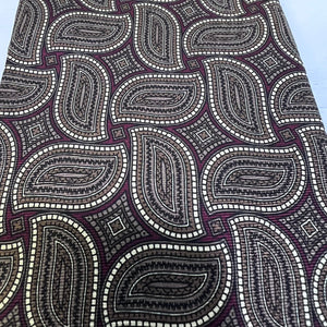 Close-up of a patterned fabric with paisley design in black, white, and purple.