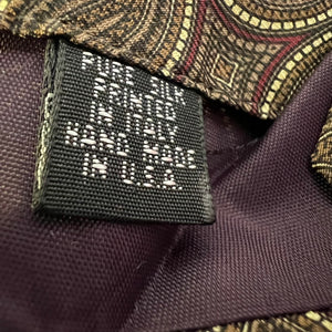 Close-up of a label on a suit with text 'Made in America' on a purple fabric background.