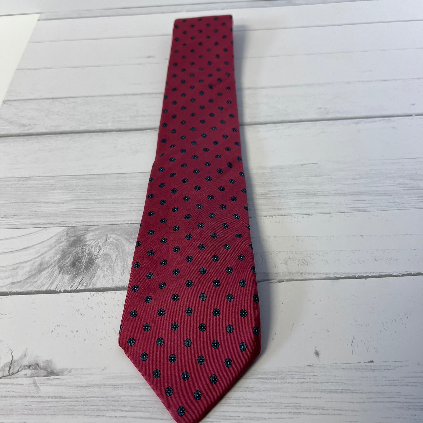 Red tie with black polka dots on a light wooden surface