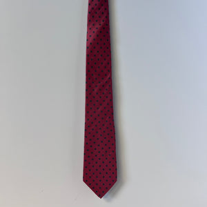Red tie with black polka dots on a light gray background