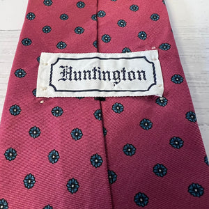 Red tie with black floral pattern and 'Huntington' label on a white background