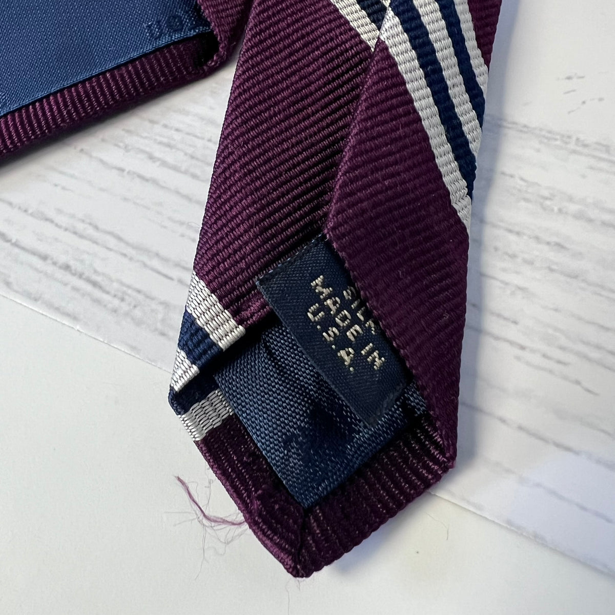 Maroon tie with 'Made in USA' label on a light background