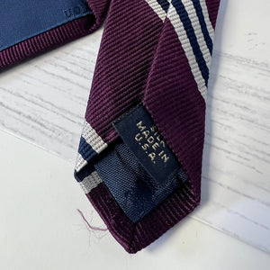 Maroon tie with 'Made in USA' label on a light background