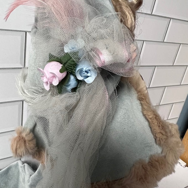 Robin Woods doll headpiece with flowers and tulle on a tiled wall background