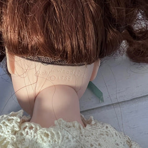 Close-up of a doll with red hair and a white lace garment, showing 'Robin Woods Inc. 1988' branding.