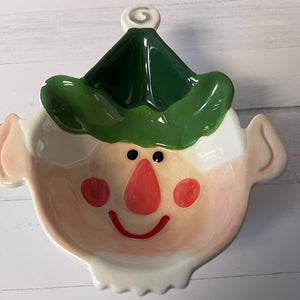 Ceramic elf face with green hat on a white background