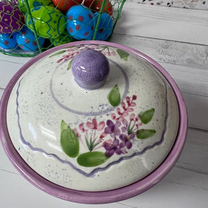 Decorative ceramic lid with floral design on a white surface