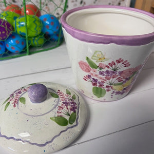 Ceramic container with floral design on a white surface