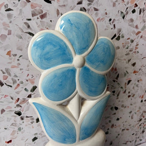 Ceramic flower-shaped vase with blue and white design on a terrazzo background