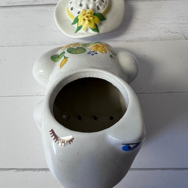 Decorative ceramic pot with floral designs on a white wooden surface