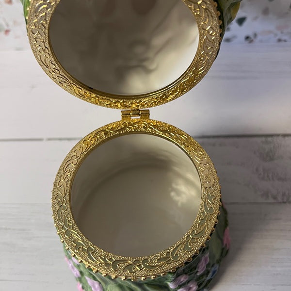 Decorative box with gold lid on a white surface